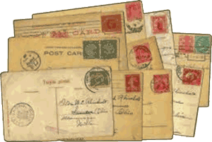 A stack of vintage postcards with writing and postmarked stamps