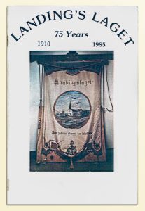 Soft cover 40-page book, stapled binding, black letters at top stating Landing's Laget, 75 Years, 1910 - 1985 over a picture of a LandingsLaget banner.